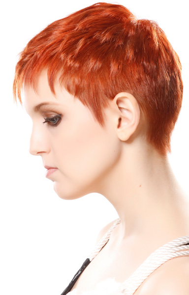Super short pixie haircut with bold red hair color.